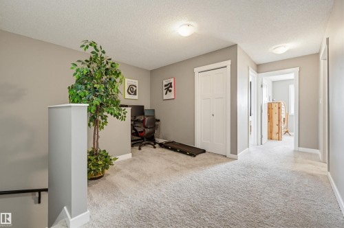 Expansive carpeted landing featuring neutral wall paint, white trim, a built-in closet with bi-fold doors, and recessed ceiling lights - 11 94 Longview Drive, Spruce Grove, AB - Indoor Photo Showing Other Room