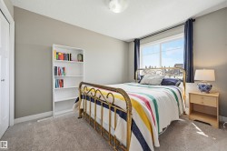 Carpeted room featuring a large window with dark curtains, light gray wall paint, and a built-in closet with a white door - 