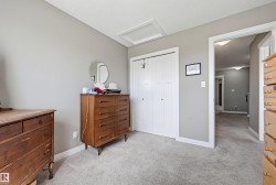 Light gray wall paint, white trim, light gray carpeting, bi-fold closet doors, and a ceiling access panel - 