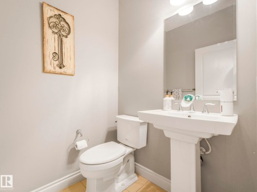 Pedestal sink with chrome fixtures and a rectangular mirror - 932 Summerside Link, Edmonton, AB - Indoor Photo Showing Bathroom