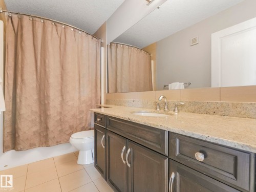 Bathroom featuring a vanity with a light-toned countertop, integrated sink, and chrome fixtures - 932 Summerside Link, Edmonton, AB - Indoor Photo Showing Bathroom