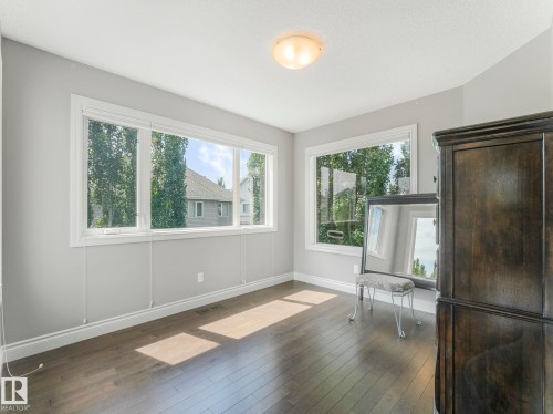 Room with light gray walls, white trim, and wood-finish flooring - 932 Summerside Link, Edmonton, AB - Indoor Photo Showing Other Room