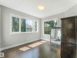 Room with light gray walls, white trim, and wood-finish flooring - 
