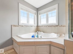 Corner soaking tub with tile surround and built-in paneling - 