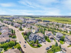 Aerial perspective of a residential neighborhood featuring detached properties with attached garages and mature landscaping - 