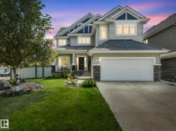 Light gray siding exterior with stone accents and dark gables - 