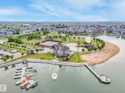 Waterfront recreational area featuring a multi-level boat dock, a sandy beach, and a children's playground - 