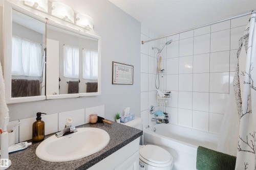 Bathroom featuring a white bathtub, white tile shower surround, and a chrome showerhead - 10831 80 Avenue, Edmonton, AB - Indoor Photo Showing Bathroom