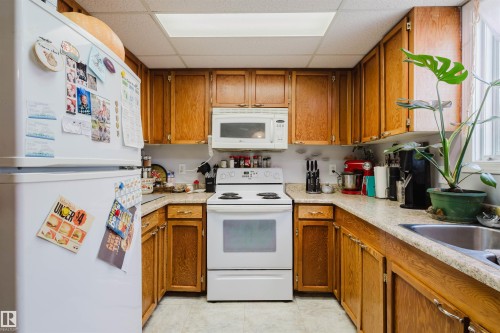 U-shaped kitchen featuring wood cabinetry and light-toned countertops - 10831 80 Avenue, Edmonton, AB - Indoor Photo Showing Kitchen