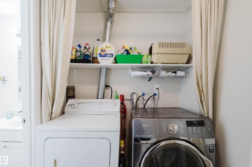 Dedicated laundry area featuring a white top-load dryer and a stainless steel front-load washing machine - 10831 80 Avenue, Edmonton, AB - Indoor Photo Showing Laundry Room
