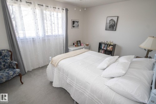 Room featuring two windows with white blinds, light gray wall paint, and gray carpet flooring - 4417 46A St, St. Paul Town, AB - Indoor Photo Showing Bedroom