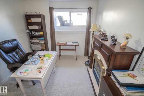 Room featuring neutral carpeting, a window with curtain rods, and white trim - 4417 46A St, St. Paul Town, AB - Indoor