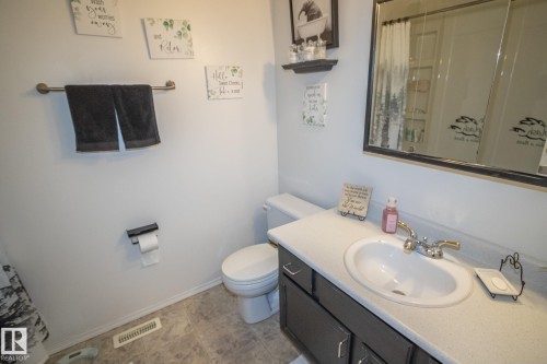 Bathroom featuring a vanity with a white countertop, an undermount sink, and a framed mirror - 4417 46A St, St. Paul Town, AB - Indoor Photo Showing Bathroom