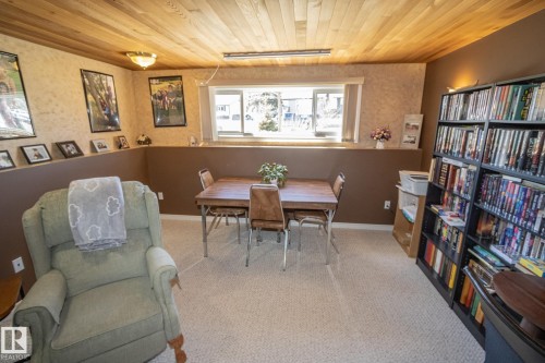 Recreation room featuring wood-finish ceiling, light-toned carpeting, and a built-in shelf - 4417 46A St, St. Paul Town, AB - Indoor