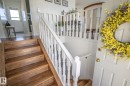 Entryway featuring wood-finish stairs with a white baluster railing and paneled door with brass hardware - 4417 46A St, St. Paul Town, AB  - Indoor Photo Showing Other Room 
