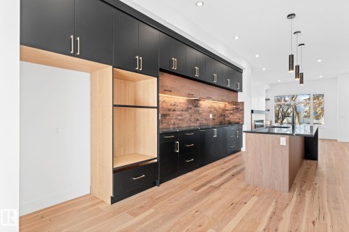 Kitchen featuring hardwood floors, black cabinetry, a wood-toned island with a dark countertop, and recessed lighting - 11019 132 St, Edmonton, AB - Indoor Photo Showing Kitchen With Upgraded Kitchen