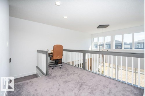 Carpeted loft space featuring white walls and a gray handrail with white spindles - 5627 Kootook Place, Edmonton, AB - Indoor Photo Showing Other Room