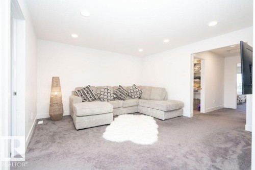 Spacious room featuring light gray carpeting, crisp white walls, and recessed lighting - 5627 Kootook Place, Edmonton, AB - Indoor Photo Showing Living Room