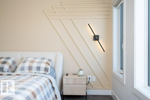 Accent wall featuring geometric wood paneling and a modern wall-mounted light fixture - 5627 Kootook Place, Edmonton, AB - Indoor Photo Showing Bedroom