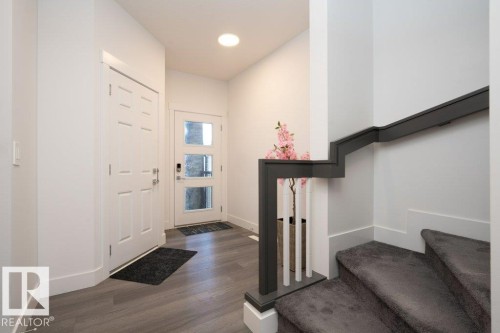 Entryway featuring wood-finish flooring, a white paneled door, and a second door with three frosted glass panels - 5627 Kootook Place, Edmonton, AB - Indoor Photo Showing Other Room