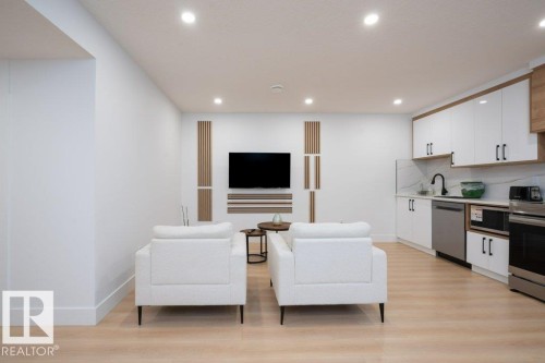 Open-concept living space featuring wood-finish flooring and recessed lighting - 5627 Kootook Place, Edmonton, AB - Indoor