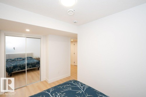 Recessed lighting illuminates the room, featuring wood-finish flooring and a mirrored sliding closet door - 5627 Kootook Place, Edmonton, AB - Indoor Photo Showing Bedroom