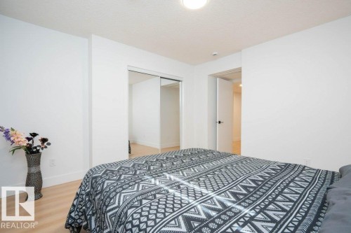 Bedroom featuring light wood-finish flooring, white walls, and a textured ceiling - 5627 Kootook Place, Edmonton, AB - Indoor Photo Showing Bedroom