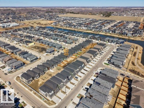 Aerial perspective of a developed residential community featuring rows of contemporary homes with dark gray roofing - 5627 Kootook Place, Edmonton, AB - Outdoor With View
