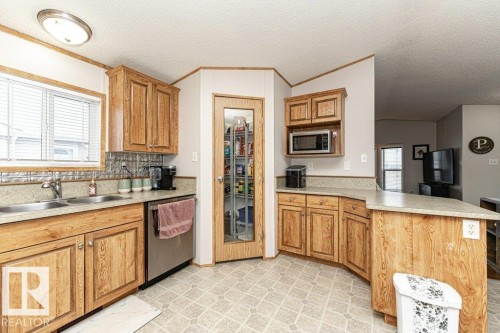 Kitchen featuring light wood cabinetry and countertops - 1637 68 Avenue, Edmonton, AB - Indoor Photo Showing Kitchen With Double Sink
