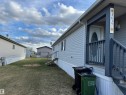 Front porch featuring a white oval-lite entry door, dark grey railing, and coordinating exterior siding - 1637 68 Avenue, Edmonton, AB  - Outdoor With Exterior 