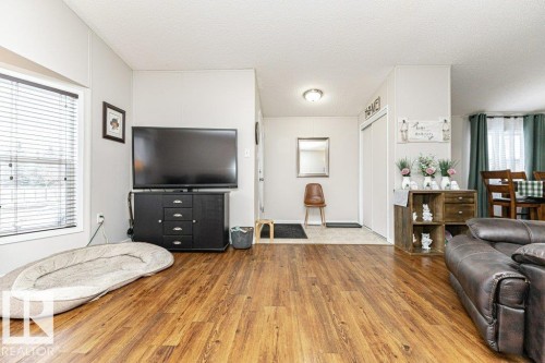 Spacious interior featuring wood-finish flooring, a large window with blinds, and light neutral wall finishes - 1637 68 Avenue, Edmonton, AB - Indoor Photo Showing Living Room