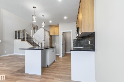 Contemporary kitchen featuring wood-finish flooring and light wood cabinetry - 3714 40 Avenue, Beaumont, AB - Indoor Photo Showing Kitchen
