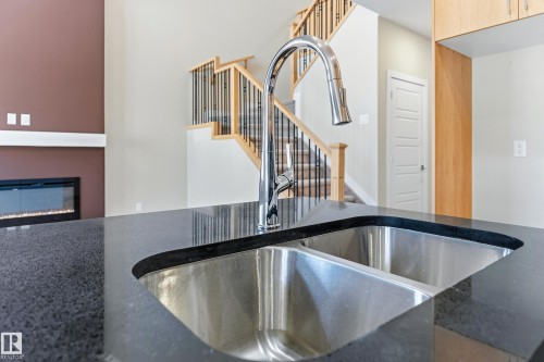Dual stainless steel undermount sink with a gooseneck faucet set into a dark countertop - 3714 40 Avenue, Beaumont, AB - Indoor Photo Showing Kitchen With Double Sink