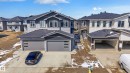 Contemporary exterior featuring a split-level design with light gray siding, dark gray accents, and an attached two-car garage - 3714 40 Avenue, Beaumont, AB  - Outdoor With Facade 