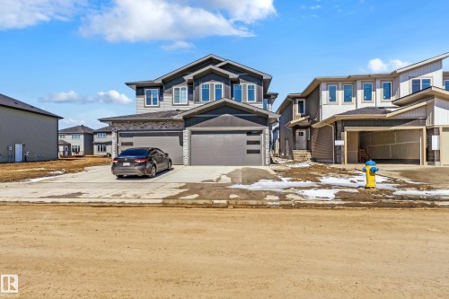 Two-story residence featuring a gray exterior with contrasting dark trim, multiple windows, and a double-wide driveway - 3714 40 Avenue, Beaumont, AB - Outdoor