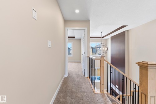 Carpeted hallway featuring warm neutral wall tones and white baseboards - 3714 40 Avenue, Beaumont, AB - Indoor Photo Showing Other Room