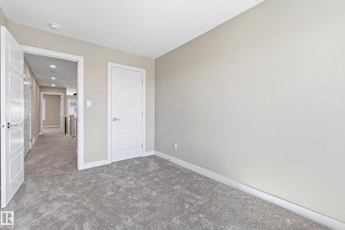 Spacious room featuring neutral wall paint, gray carpeting, and white trim - 3714 40 Avenue, Beaumont, AB - Indoor Photo Showing Other Room