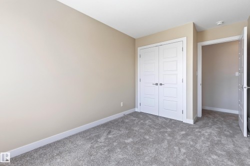 Neutral tone walls complement the soft gray carpet flooring - 3714 40 Avenue, Beaumont, AB - Indoor Photo Showing Other Room