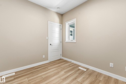 Wood-finish flooring throughout, complemented by light beige wall paint and bright white trim - 3714 40 Avenue, Beaumont, AB - Indoor Photo Showing Other Room