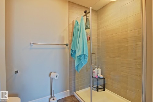 Walk-in shower with clear glass enclosure and light-toned tile surround - 9711 223 Street, Edmonton, AB 
