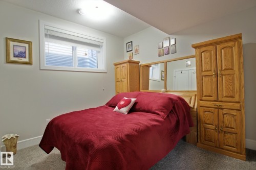 Bedroom featuring a perimeter window, light gray wall paint, and gray carpet flooring - 9711 223 Street, Edmonton, AB 