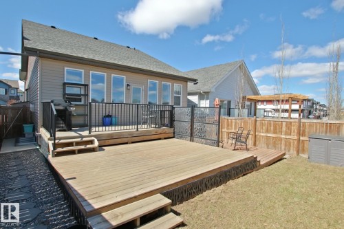 Expansive wood deck featuring black metal railings and direct access to the interior - 9711 223 Street, Edmonton, AB 