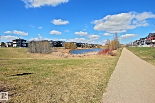 Manicured green spaces with paved walking trails bordering a naturalized pond area - 9711 223 Street, Edmonton, AB 