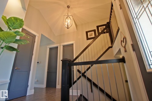 Entryway featuring a contemporary staircase with dark wood handrails and metal balusters - 9711 223 Street, Edmonton, AB 