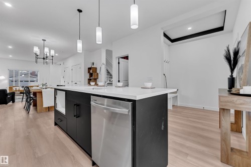 Modern kitchen island with quartz countertop, integrated stainless steel dishwasher, and matte black cabinetry - 269 Falcon Crescent, Leduc, AB - Indoor Photo Showing Kitchen With Upgraded Kitchen