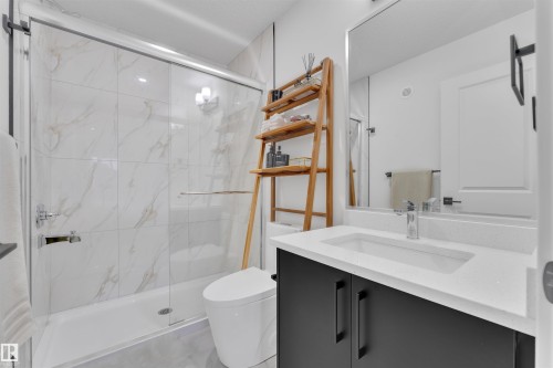 Contemporary bathroom featuring a spacious shower with sliding glass doors and white-veined wall tiles - 269 Falcon Crescent, Leduc, AB - Indoor Photo Showing Bathroom