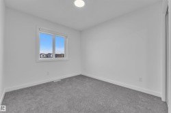 Bright room with a window, light gray carpeting, crisp white walls, white baseboards, and a flush-mount ceiling light fixture - 
