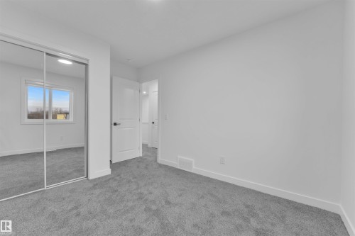 Bedroom featuring grey carpet flooring, white walls, white trim, a window with a white frame, and a mirrored closet door - 269 Falcon Crescent, Leduc, AB - Indoor Photo Showing Other Room