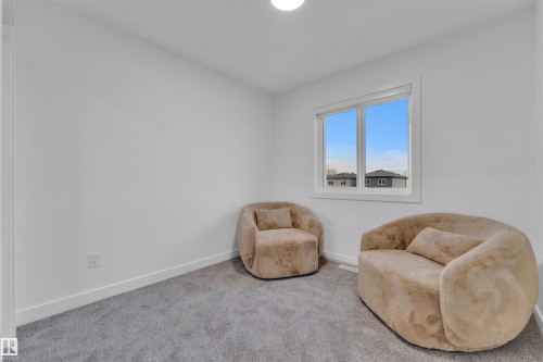 Room featuring neutral-toned walls, a large window, white trim, and light grey carpet flooring - 269 Falcon Crescent, Leduc, AB - Indoor