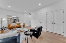 Open-concept living space featuring wood-finish flooring, recessed lighting, and a large window with white trim - 269 Falcon Crescent, Leduc, AB  - Indoor Photo Showing Living Room 